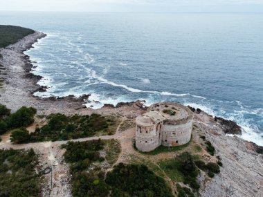 Karadağ 'ın Herceg Novi kenti yakınlarındaki Mamula Kalesi ve kayalık kıyılarının havadan görünüşü, aşağıda dalgalar çarpıyor. g.