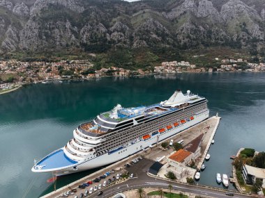 Karadağ 'ın Kotor kentinde, eski kasaba ve dağlarla çevrili marina yakınlarındaki bir yolcu gemisinin hava görüntüsü. C.