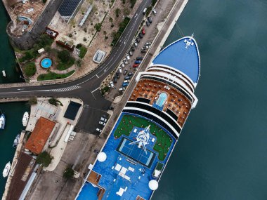 Karadağ 'ın Kotor kentinde, eski kasaba ve dağlarla çevrili marina yakınlarındaki bir yolcu gemisinin hava görüntüsü. C.