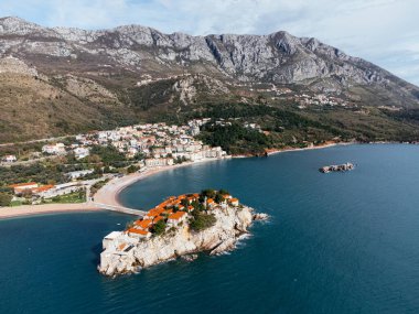 Karadağ 'ın Adriyatik Denizi kıyısındaki kıyı köyüne bağlanan ada otelinin havadan görünüşü. c.