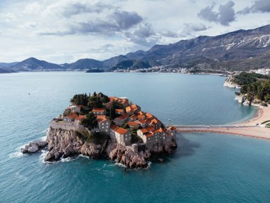 Karadağ 'ın Adriyatik Denizi kıyısındaki kıyı köyüne bağlanan ada otelinin havadan görünüşü. c.