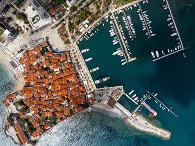 Karadağ 'ın Adriyatik kıyısındaki Budva kentinin marina ve kırmızı kiremitli çatılarıyla hava manzarası. g.
