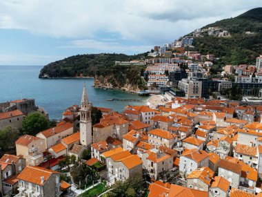 Karadağ 'ın Adriyatik kıyısındaki Budva kentinin marina ve kırmızı kiremitli çatılarıyla hava manzarası. g.
