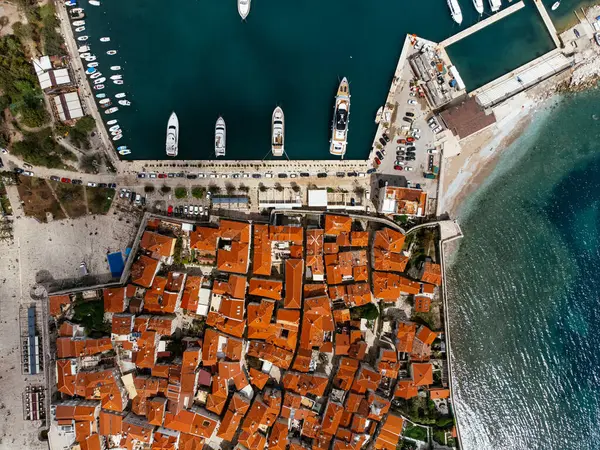 Karadağ 'ın Adriyatik kıyısındaki Budva kentinin marina ve kırmızı kiremitli çatılarıyla hava manzarası. g.