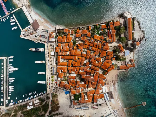 Karadağ 'ın Adriyatik kıyısındaki Budva kentinin marina ve kırmızı kiremitli çatılarıyla hava manzarası. g.