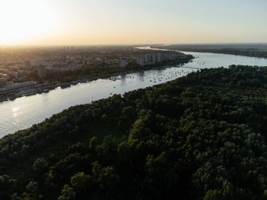 Nehir kıyısının havadan görünüşü, botlar ve şehrin altın saatinde ufuk çizgisi. g .