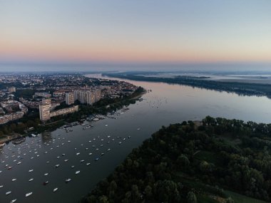 Nehir kıyısının havadan görünüşü, botlar ve şehrin altın saatinde ufuk çizgisi. g .