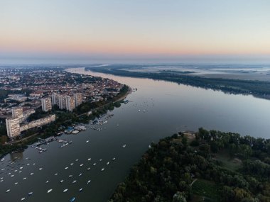 Nehir kıyısının havadan görünüşü, botlar ve şehrin altın saatinde ufuk çizgisi. g .