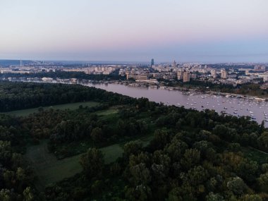 Nehir kıyısının havadan görünüşü, botlar ve şehrin altın saatinde ufuk çizgisi. g .