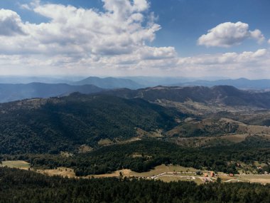 Yazın dağlık tepeleri ve dağınık evleri olan Zlatibor Highlands köyünün hava manzarası. g.