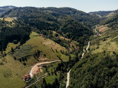 Yazın dağlık tepeleri ve dağınık evleri olan Zlatibor Highlands köyünün hava manzarası. g.