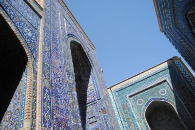 Özbekistan 'ın Semerkand kentindeki Şah-i-Zinda anıtsal mezarlığında seramik tuğlalar ve kiremitlerle süslü zengin bir cephe.