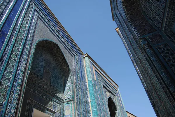 Özbekistan 'ın Semerkand kentindeki Şah-i-Zinda anıtsal mezarlığında seramik tuğlalar ve kiremitlerle süslü zengin bir cephe.