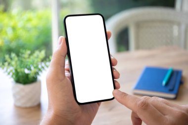 Kafe 'deki masanın izole ekran arka planına sahip erkek eller telefonu tutuyor.