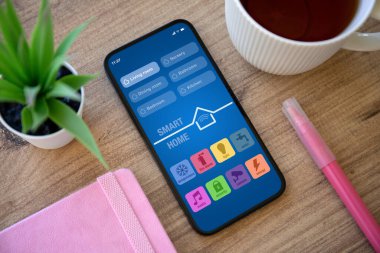 Pembe not defteri ve keçeli kalemle ekranda akıllı ev uygulamalı telefon 