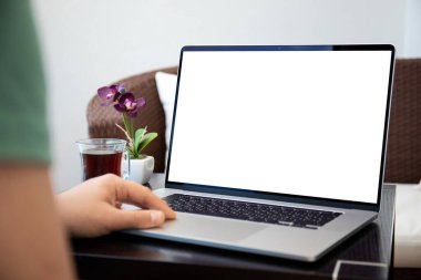 Erkek elleri dizüstü bilgisayarda, kafeteryadaki bir masada ayrı ekranda.