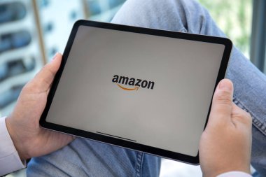 Alanya, Turkey - May 11, 2021: Man holding Apple iPad Air Space Gray with Online shopping service Amazon on the screen. iPad was created and developed by the Apple inc