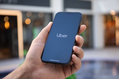 Alanya, Türkiye - 27 Eylül 2022: Ekranda Taksi uygulamalı iPhone 14 ile el ele tutuşan adam.