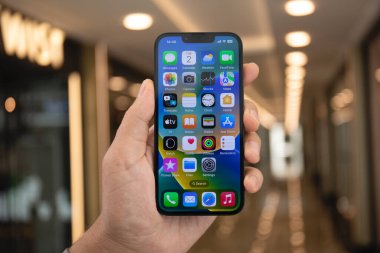 Alanya, Türkiye - 2 Mayıs 2023: Ekranda IOS 16 ekranlı iPhone 14 ile el ele tutuşan adam.
