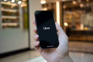 Alanya, Türkiye - 2 Mayıs 2023: Ekranda Taksi uygulamalı iPhone 14 ile el ele tutuşan adam.