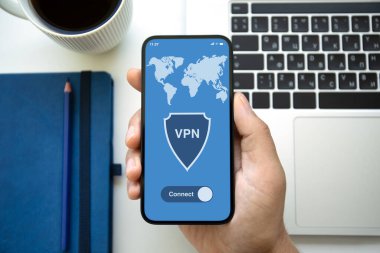 Ofiste dizüstü bilgisayarı olan ve ekranda VPN uygulaması olan erkek el bilgisayarı.