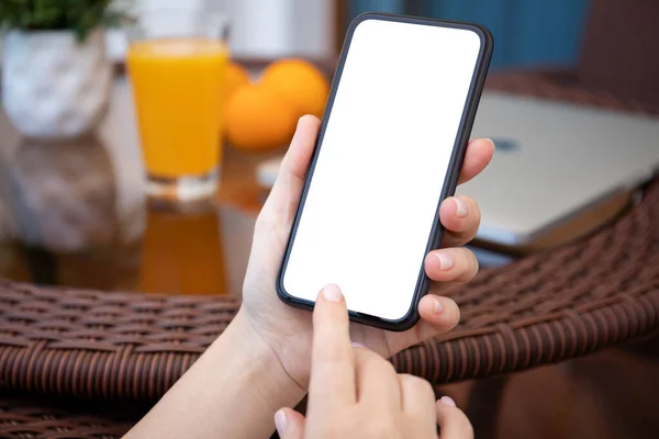 女性の手はカフェでオレンジジュースとテーブルの独立した画面の背景を持つ携帯電話を保持します — ストック写真