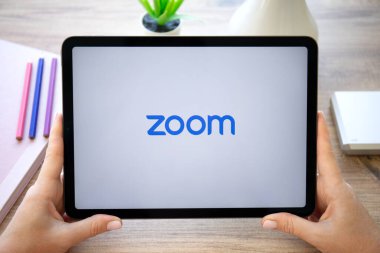 Alanya, Türkiye - 20 Ekim 2022: Kadın elleri Zoom Video İletişim uygulamasını arayarak Apple iPad Air Gray 'i tutuyor.