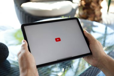 Alanya, Türkiye - 20 Eylül 2023: Apple iPad Air Space Gray uygulaması ile el ele tutuşan adam YouTube üzerinden ekranda yayın medyası ve video sunuyor.