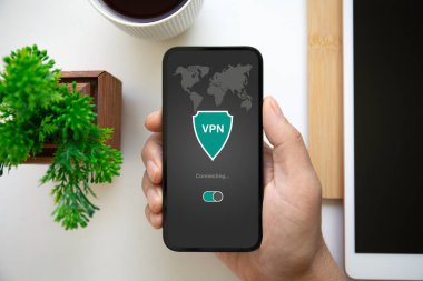 Ofisteki masanın üzerinde uygulamalı VPN ile el ele tutuşan adam.