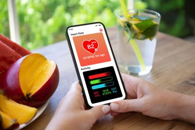 Uygulama kalbi olan ve portakallı limonatanın arka planında faaliyet gösteren bir kadın el ele tutuşuyor.