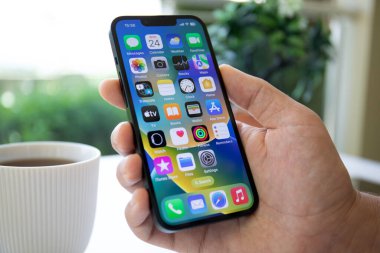 Alanya, Türkiye - 24 Mayıs 2023: Ekranda IOS 16 ekranlı iPhone 14 ile el ele tutuşan adam