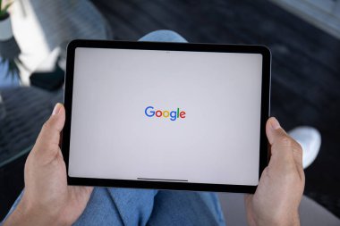 Alanya, Türkiye - 20 Eylül 2023: iPad Air Space Gray 'i tutan adam ve sosyal ağ hizmeti Google ekranda.