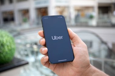Alanya, Türkiye - 26 Eylül 2023: Ekranda Taksi uygulamalı iPhone 14 ile el ele tutuşan adam. 