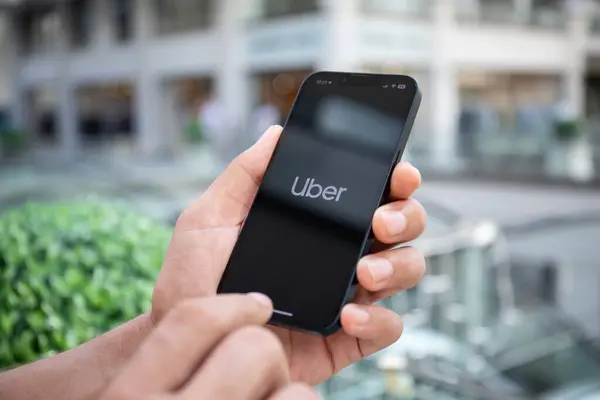 stock image Alanya, Turkey - September 26, 2023: Man hand holding iPhone 14 with application Taxi Uber on the screen.