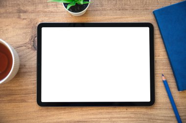 Ofisinde mavi not defteri olan, ahşap masadaki izole ekranlı tablet