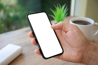 Kafe 'deki ahşap masanın arka planında tek ekran görüntüsü olan el ele tutuşan bir adam.