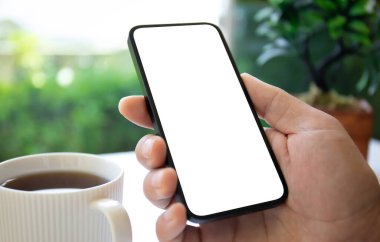 Yeşil kafenin izole ekran arka planına sahip erkek eller telefonu tutar