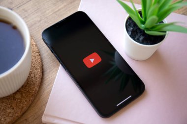 Alanya, Türkiye - 6 Ekim 2022: Uygulama YouTube ile Telefon Apple iPhone 14 masadaki ekranda canlı medya ve video sunuyor