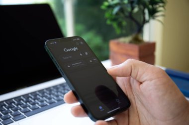 Alanya, Türkiye - 25 Mayıs 2023: Ekranda sosyal ağ hizmeti Google ile Apple iPhone 14 'ü tutan adam eli