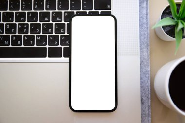 Ofisteki masadaki dizüstü bilgisayarın izole ekran arka planına sahip telefon