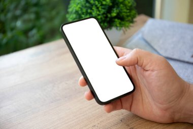 Kafe 'deki ahşap masanın arka planında tek ekran görüntüsü olan el ele tutuşan bir adam.