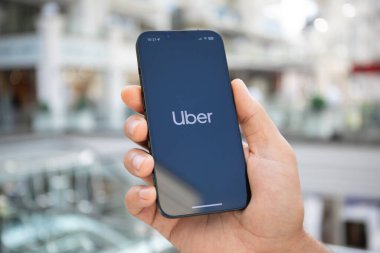 Alanya, Türkiye - 26 Eylül 2023: Ekranda Taksi uygulamalı iPhone 14 ile el ele tutuşan adam. 