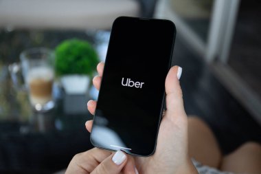 Alanya, Türkiye - 5 Ekim 2023: Ekranda Taksi uygulamalı iPhone 14 ile el ele tutuşan kadın.