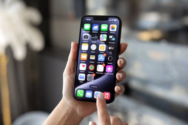 Alanya, Türkiye - 24 Ekim 2023: Ekranda ev kilitli IOS 17 ekranlı iPhone 14 ile el ele tutuşan kadın.