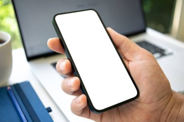 Ofisteki dizüstü bilgisayarında izole ekranı olan erkek el ele tutuşan telefon.