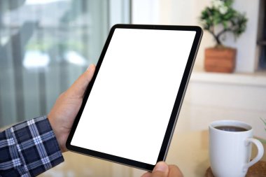 Evin arka planında izole ekran bulunan bilgisayar tabletini tutan erkek elleri