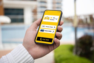 man hand holding phone with application call taxi screen on the street