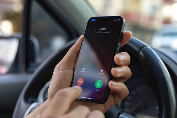 Alanya, Turkey - November 7, 2023: Man hand holding iPhone 14 with call phone on the screen IOS 17.