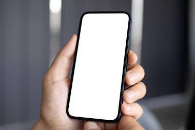 Erkek el ele tutuşan telefon, arka planda izole edilmiş gri duvar.