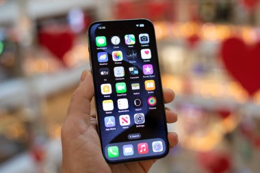 Alanya, Türkiye - 22 Aralık 2023: İnsan eli iPhone 15 Pro Max ile ana ekran IOS 17 ekranda